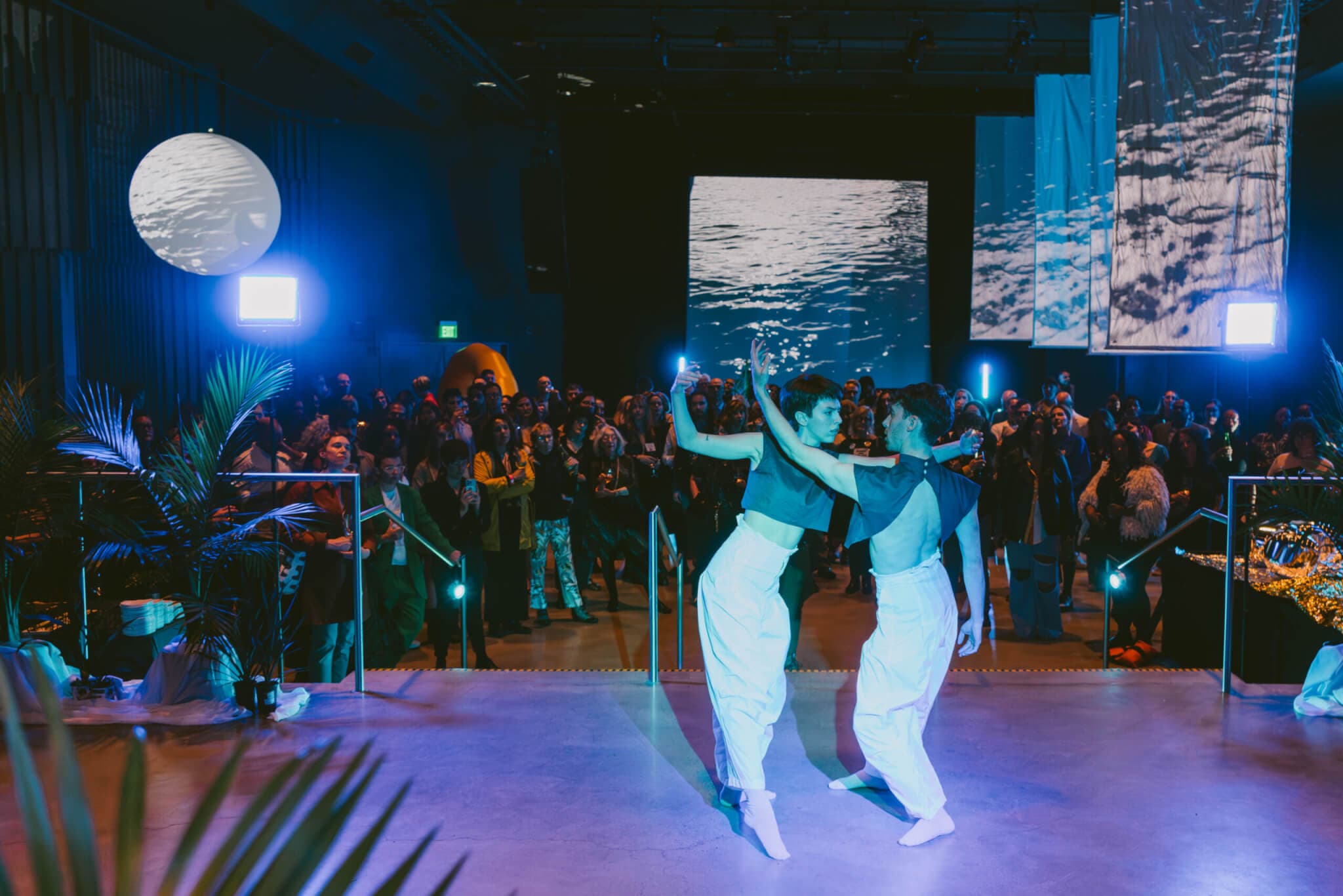 Two dancers perform under purple light at the Boston Art Review fifth anniversary party.